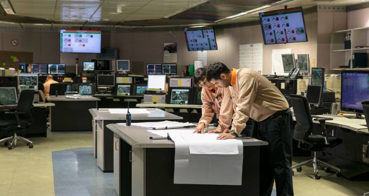 Empleados mirando un mapa en la sala de control